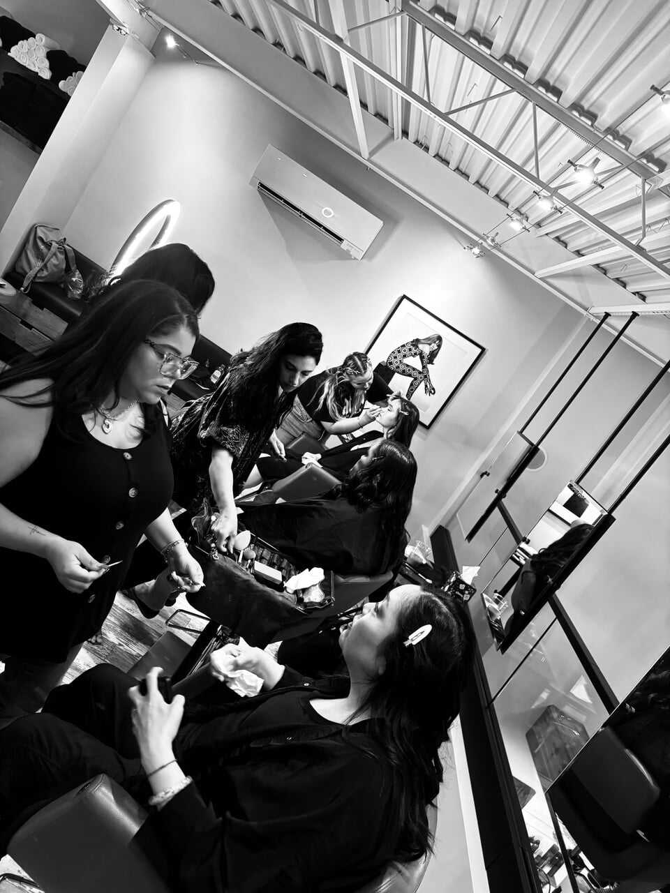 Salon stylists working on clients' hair in a modern, minimalist setting.