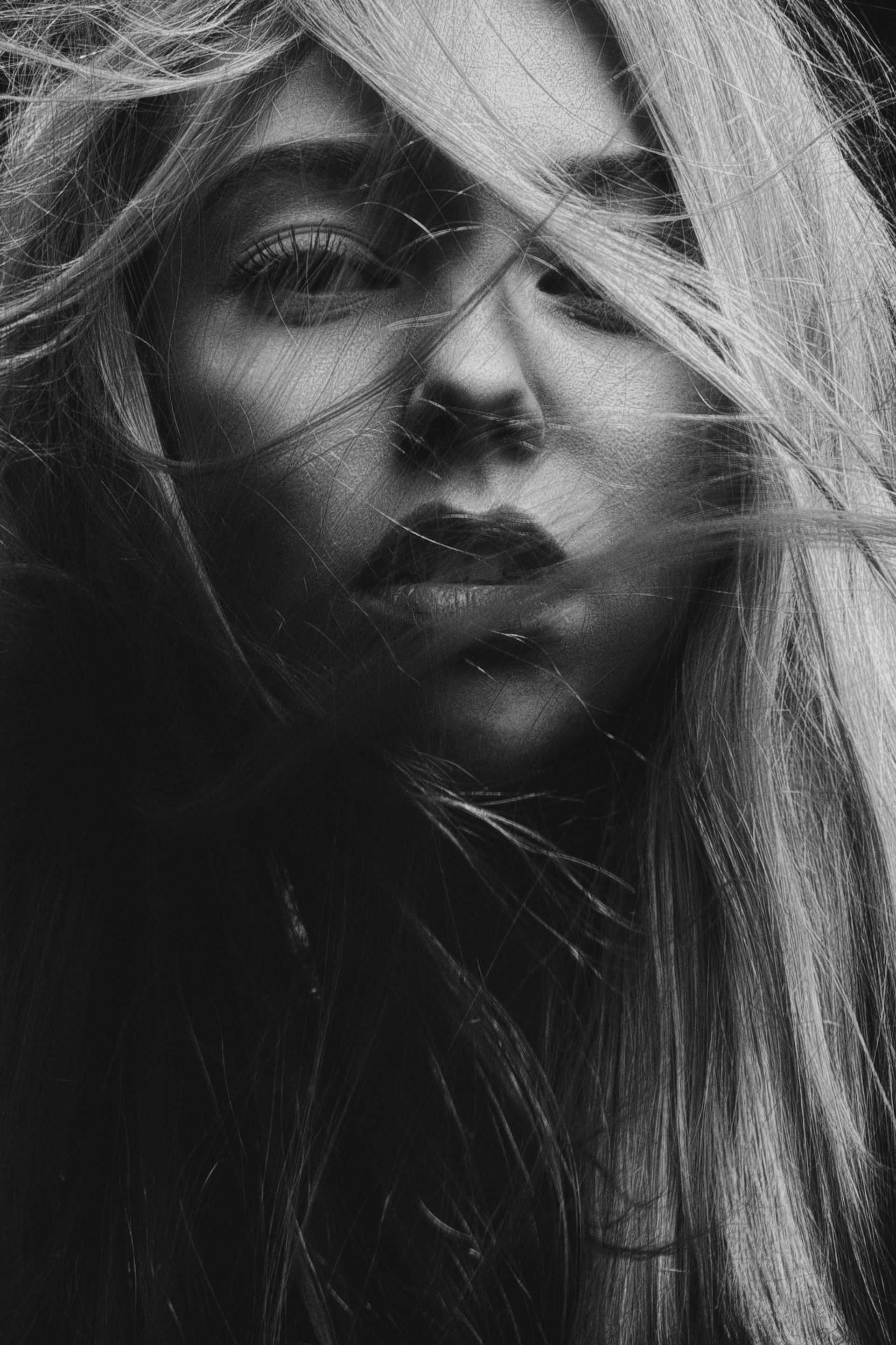 Black and white portrait of a person with windblown hair.